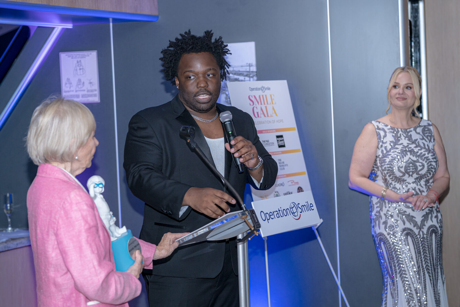 Reggie Prevail giving remarks at the Operation Smile podium