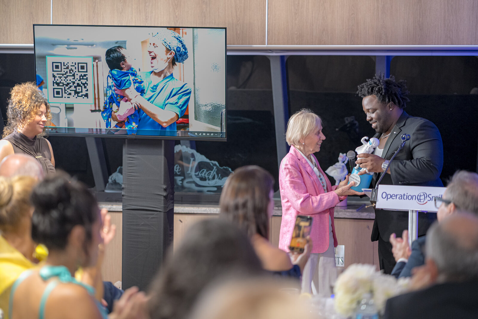 Kathy Magee hands Reggie Prevail the Cotto Changemaker Award aboard the Biscayne Lady