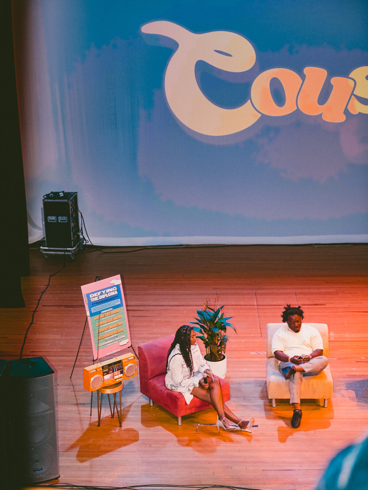Wide view of the CousinzCon stage with the Defying The Diploma panel sign