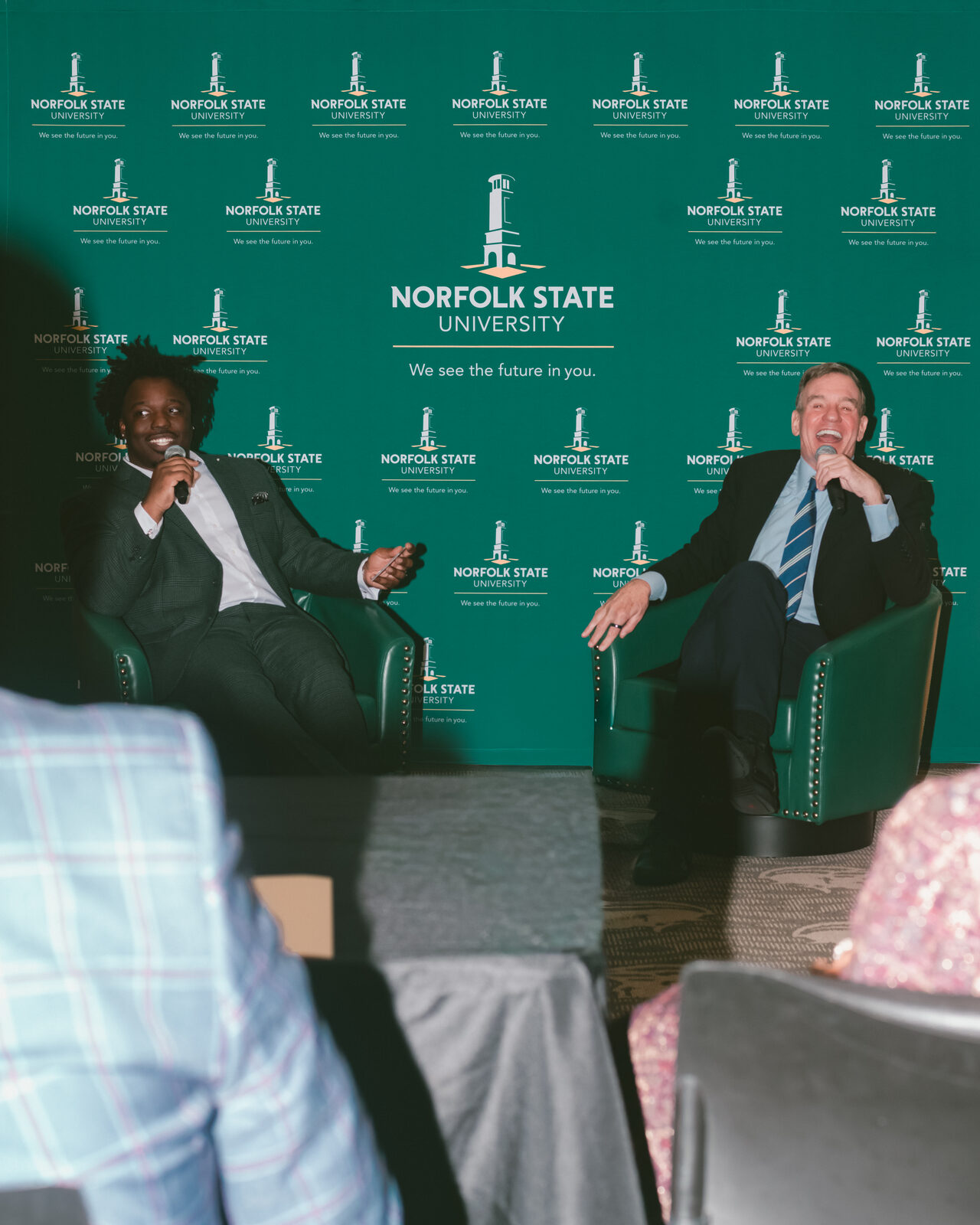 Reggie Prevail on stage interviewing U.S. Senator Mark Warner at Norfolk State University